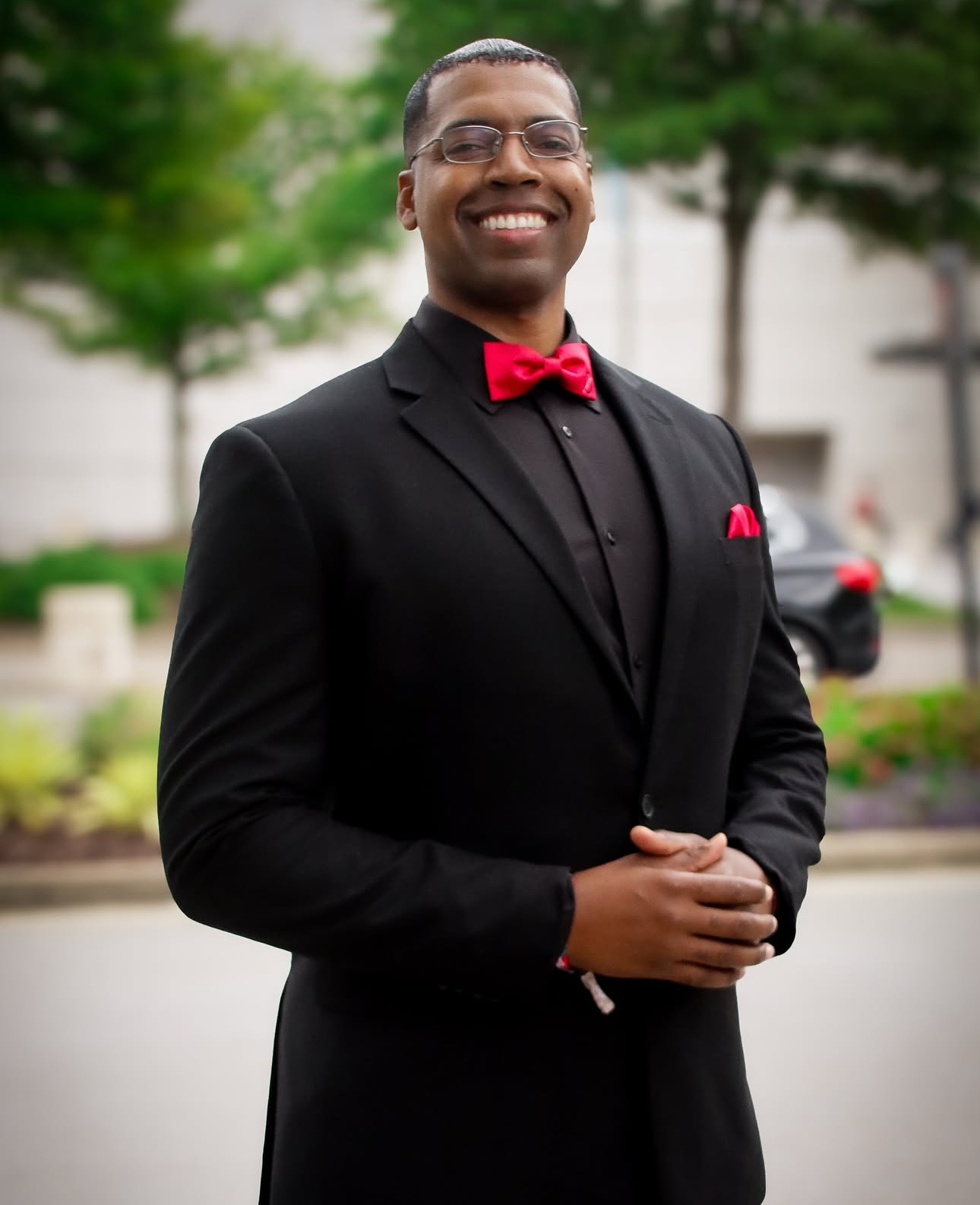 Brother Rizza Islam in a black suit with a red bow tie